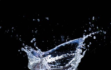 Su siyah bir zemine saçılmış. Siyah arka planda su sıçraması. Siyah arkaplanda izole sıçrama