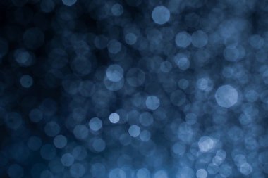 Bokeh 'in koyu mavi soyut arka planı. Renkli yanıp sönen ışıklar ışık arkaplanını tıkıyor.