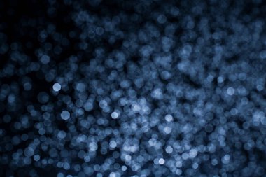 Bokeh 'in koyu mavi soyut arka planı. Renkli yanıp sönen ışıklar ışık arkaplanını tıkıyor.