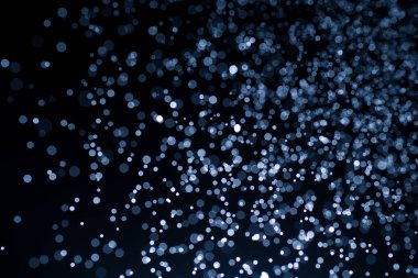 Bokeh 'in koyu mavi soyut arka planı. Renkli yanıp sönen ışıklar ışık arkaplanını tıkıyor.