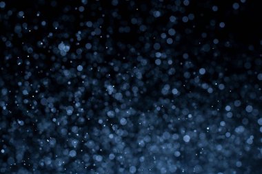 Bokeh 'in koyu mavi soyut arka planı. Renkli yanıp sönen ışıklar ışık arkaplanını tıkıyor.