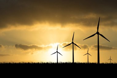 Rüzgar türbinleri gece boyunca enerji enerjisi üretir. Güneş batıyor. Siluetler, rüzgar türbinleri, akşamları temiz enerji.
