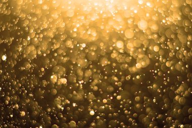 Altın arka plan. Soyut altın arkaplan. Şenlikli Altın Noel Arkaplanı. Arkaplan altın ışıkla parıldıyor, bokeh sönmüş ışık.