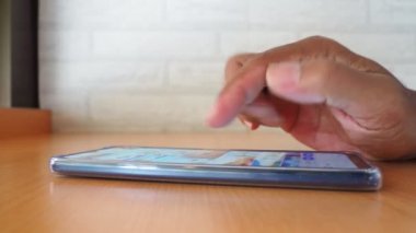 side view Man's hand using smartphone in coffee shop to search for information