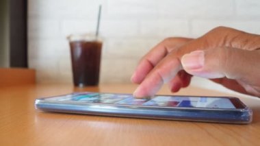 side view Man's hand using smartphone in coffee shop to search for information