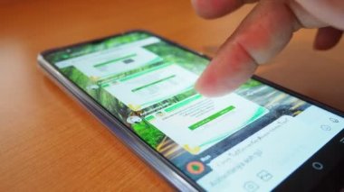 side view Man's hand using smartphone in coffee shop to search for information