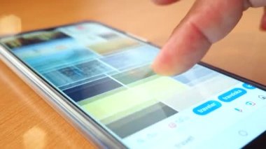 Kahve dükkanında bilgi aramak için akıllı telefonu kullanan adamın eli.