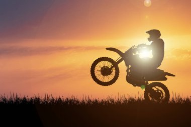 Motokros motosikletinin silueti ön tekerleği kaldırıyor. Macera ve Eylem Kavramları