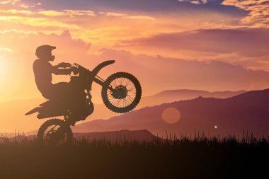 Motokros motosikletinin silueti ön tekerleği kaldırıyor. Macera ve Eylem Kavramları