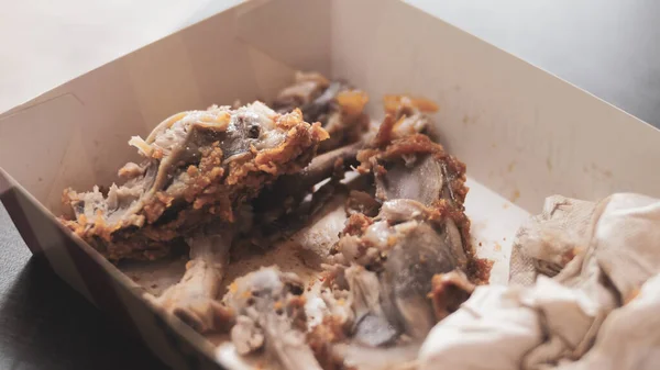 Food waste concept. Bones of fried chicken in a restaurant