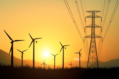 Rüzgar türbininin siluetleri akşam saatlerinde tarlalarda elektrik üretmek için kullanılır..