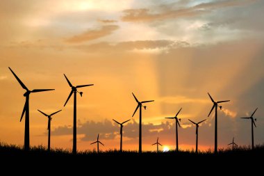Rüzgar türbini elektrik üretmek için kullanılır. Yenilenebilir Enerji Konseptleri ve Dünya Enerji Tasarruf Edin. Gün batımında rüzgar santralinin silueti