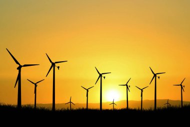 Rüzgar türbini elektrik üretmek için kullanılır. Yenilenebilir Enerji Konseptleri ve Dünya Enerji Tasarruf Edin. Gün batımında rüzgar santralinin silueti