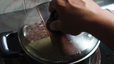 man hand opening pot with Stewed eggs and pork belly.  home cooking ideas