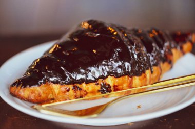 Beyaz tabakta çikolatalı kruvasan.