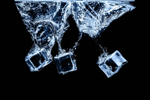 Ice cubes in water on studio dark background. The concept of freshness with coolness from ice cubes.