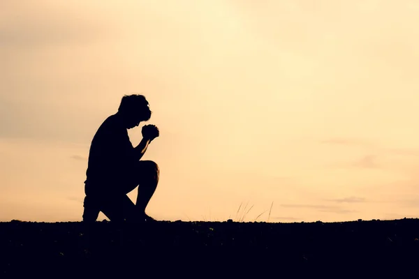 Silhouettes of men sitting and praying for blessings. hope concept