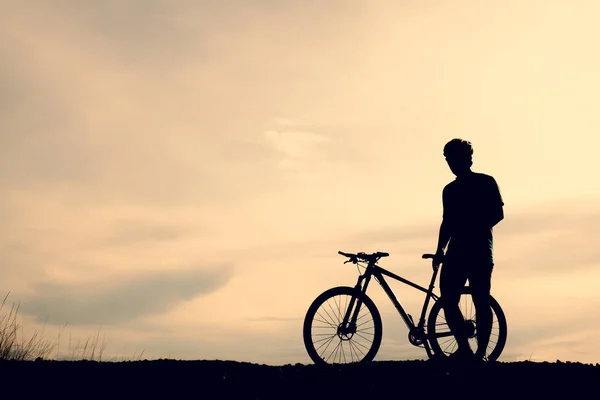 Silhouettes of mountain bikes and cyclists in the evening happily. Travel and fitness concept