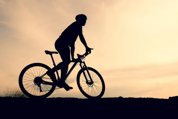 Silhouettes of mountain bikes and cyclists in the evening happily. Travel and fitness concept