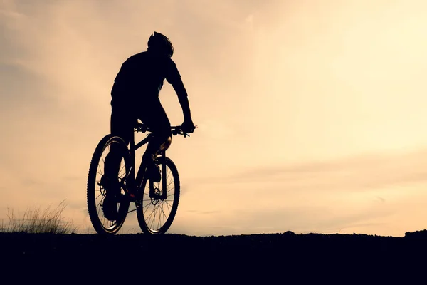 Silhouettes of mountain bikes and cyclists in the evening happily. Travel and fitness concept