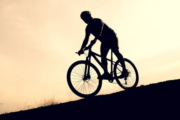 Silhouettes of mountain bikes and cyclists in the evening happily. Travel and fitness concept