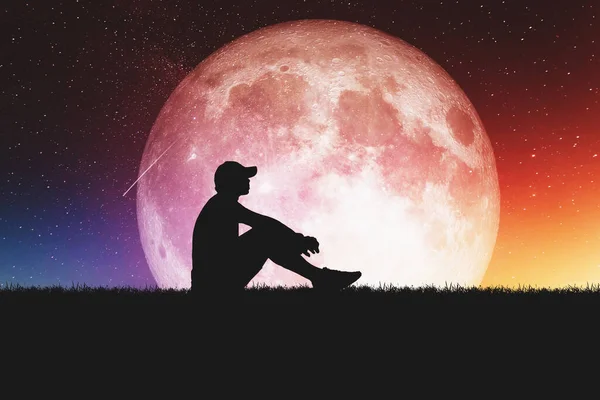 Concept of loneliness and disappointment in love. Sad man sitting against the moon, element of the picture is decorated by NASA