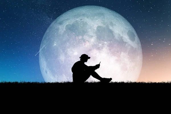 Concept of loneliness and disappointment in love. Sad man sitting against the moon, element of the picture is decorated by NASA