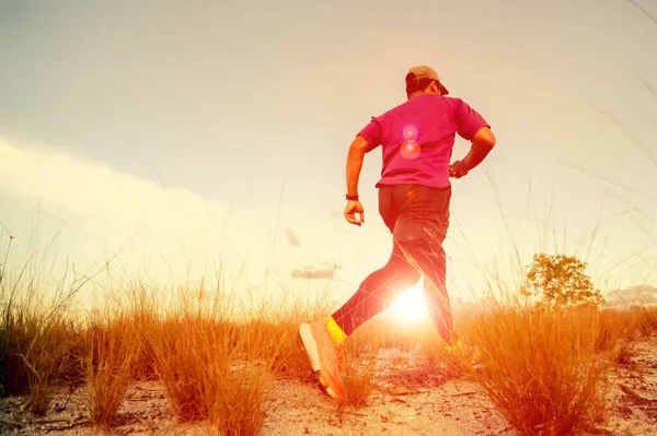 Concept of starting exercise with running. man running in the evening meadow