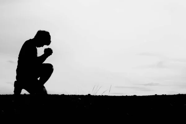 Silhouettes of men sitting and praying for blessings. hope concept