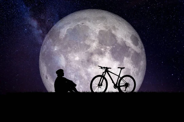 man with bicycle with the moon in the background