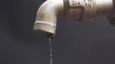 Temiz su eksikliği krizinin konsepti. Su damlacıkları akan musluk. Su musluğu, dışarı çıkmadan