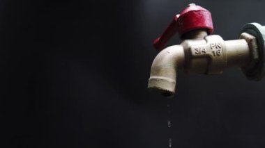 Temiz su eksikliği krizinin konsepti. Su damlacıkları akan musluk. Su musluğu, dışarı çıkmadan