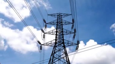 Elektrik kulesinin altında hareket eden küçük bulutlu mavi gökyüzünün arkaplanı 