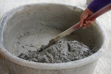 İşçiler çimentoya ıslak çimento karıştırıcı leğen kullanıyorlar, seçici odak                                                                                       