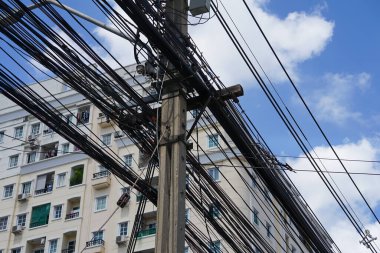Elektrik kabloları ve iletişim kabloları şehir merkezindeki sokak lambası direğine bağlı, seçici odaklı..                               