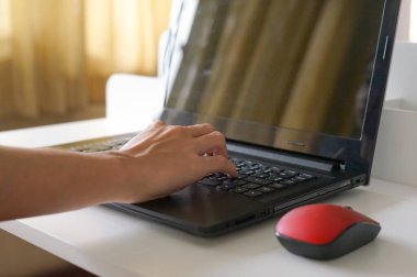 Beyaz masada dizüstü bilgisayar kullanan erkek eli, seçici odaklanma. ev kavramından teknoloji çalışması                              