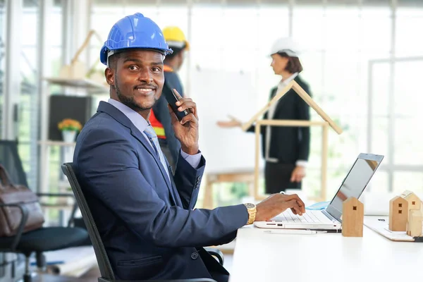 Afrika kökenli Amerikan mühendislik veya mimarlık işletme ortaklığı. Ofiste iş konuşmak için akıllı telefon kullanılıyor..