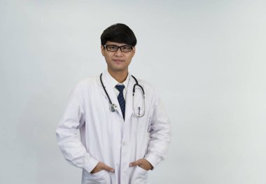 Üzerinde steteskop bulunan, beyaz arka planda duran, metin için fotokopi alanı olan, üniformalı çekici genç doktor portresi