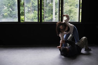 aggressive woman victim is fighting against robber in an old dirty abandoned house, woman self defense concept