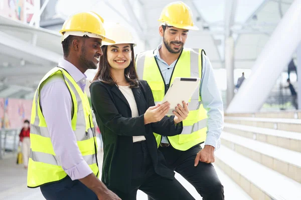 Mühendisler inşaat alanında çalışıyor, takım çalışması konuşuyor ve açık hava inşaatını tartışıyorlar.                                                             