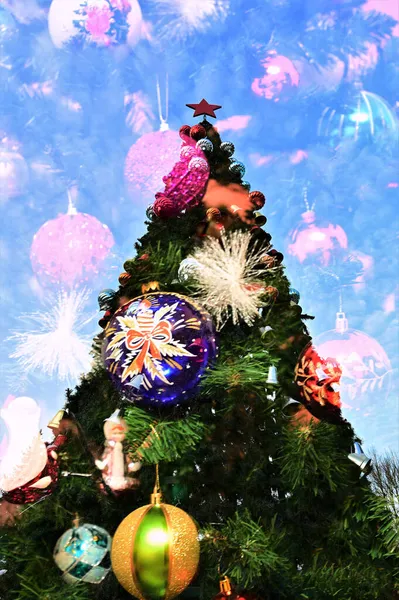 青空を背景におもちゃで飾られたクリスマスツリー 多重露光モードで撮影された写真 — ストック写真