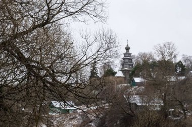 Rusya 'nın Torzhok kentindeki antik Tikhvin Icon kilisesinin ağaçlarının arasından bakın. Sonbaharın sonlarında güzel bir manzara