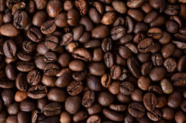 Kahve fasülyesi geçmişi. Tüm yüzeyde kavrulmuş kahve çekirdekleri. Kahverengi kahve. Üst manzaralı düz bir düzen. Yakın plan.