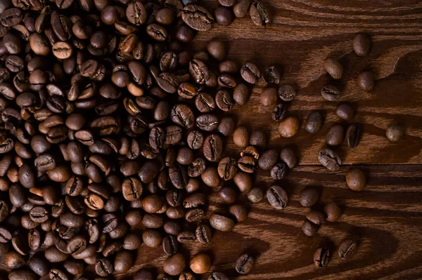 コーヒー豆の背景 木製のテーブルの上にコーヒー豆を炒めた ブラウンコーヒー トップビューのフラットレイアウト — ストック写真