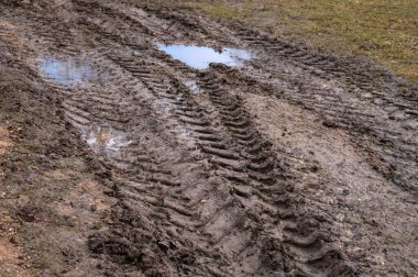 Sonbaharın sonlarında yağmurdan sonra off-road 'a yakın. Kasaba yolunda su birikintileri ve lastik izleri var. Kırsal bölgelerdeki insanların hareket güçlüğü