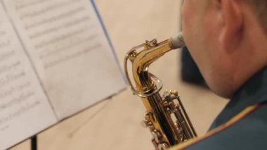 Pirinç askeri bantlar. Eller yakın çekim enstrümanları. Orkestra kapalı mekanda çalıyor..