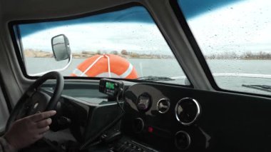 Bir hovercraft su üstünde gider. Kulübeden manzara. Dışarıda sonbahar var.