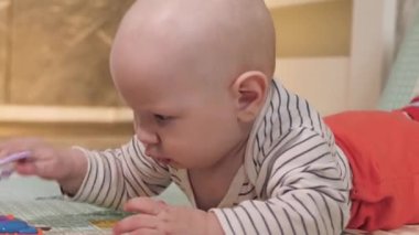 Bir bebek yerde eğitici oyuncaklarla oynuyor. Etrafta kimse yok. Güzel. Yakın çekim.