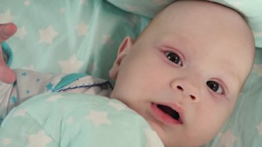 Küçük bir çocuk yemek yemeye çalışır ve yaramazlık yapar. Bebek şişesi. Yüzüne yakın.