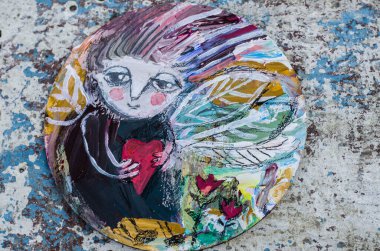 Yuvarlak ahşap üzerine kalp çizimi yapan bir peri. Soyut fantezi çizimi.